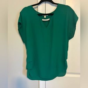 Women’s green blouse with gold accent bar at v-cut opening.